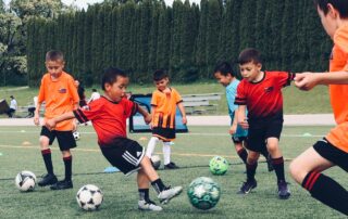 Youth soccer player sprinting through timing gates while wearing a GPS vest during a sports science session in Burnaby, BC