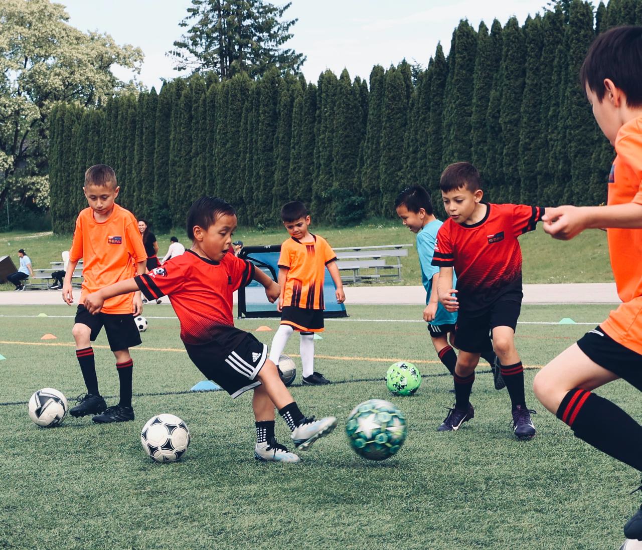 Youth soccer player sprinting through timing gates while wearing a GPS vest during a sports science session in Burnaby, BC